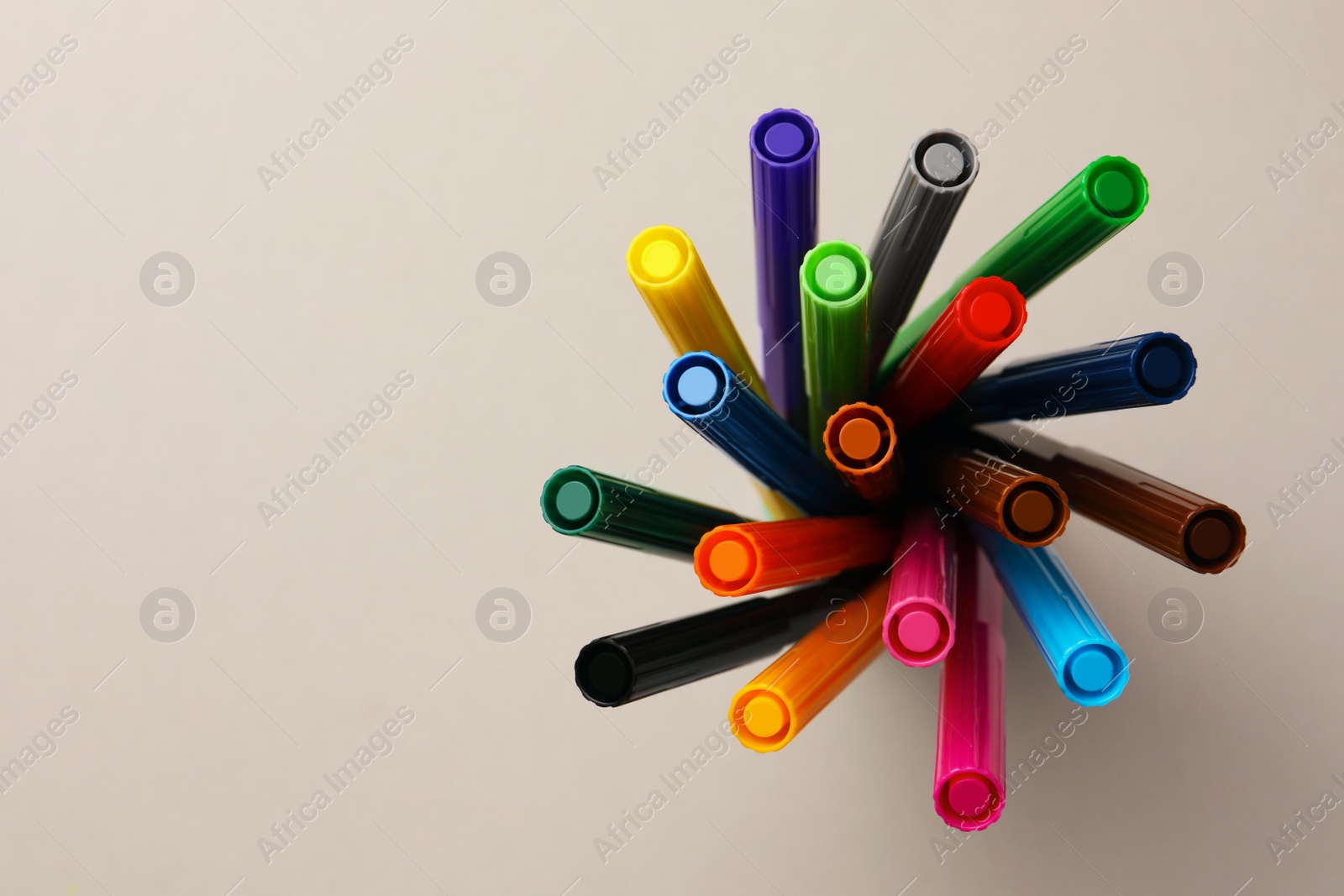 Photo of Many bright markers on light grey background, top view. Space for text