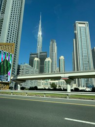 Photo of Dubai, United Arab Emirates - May 2, 2023: Beautiful view of Burj Khalifa and buildings in city under blue sky