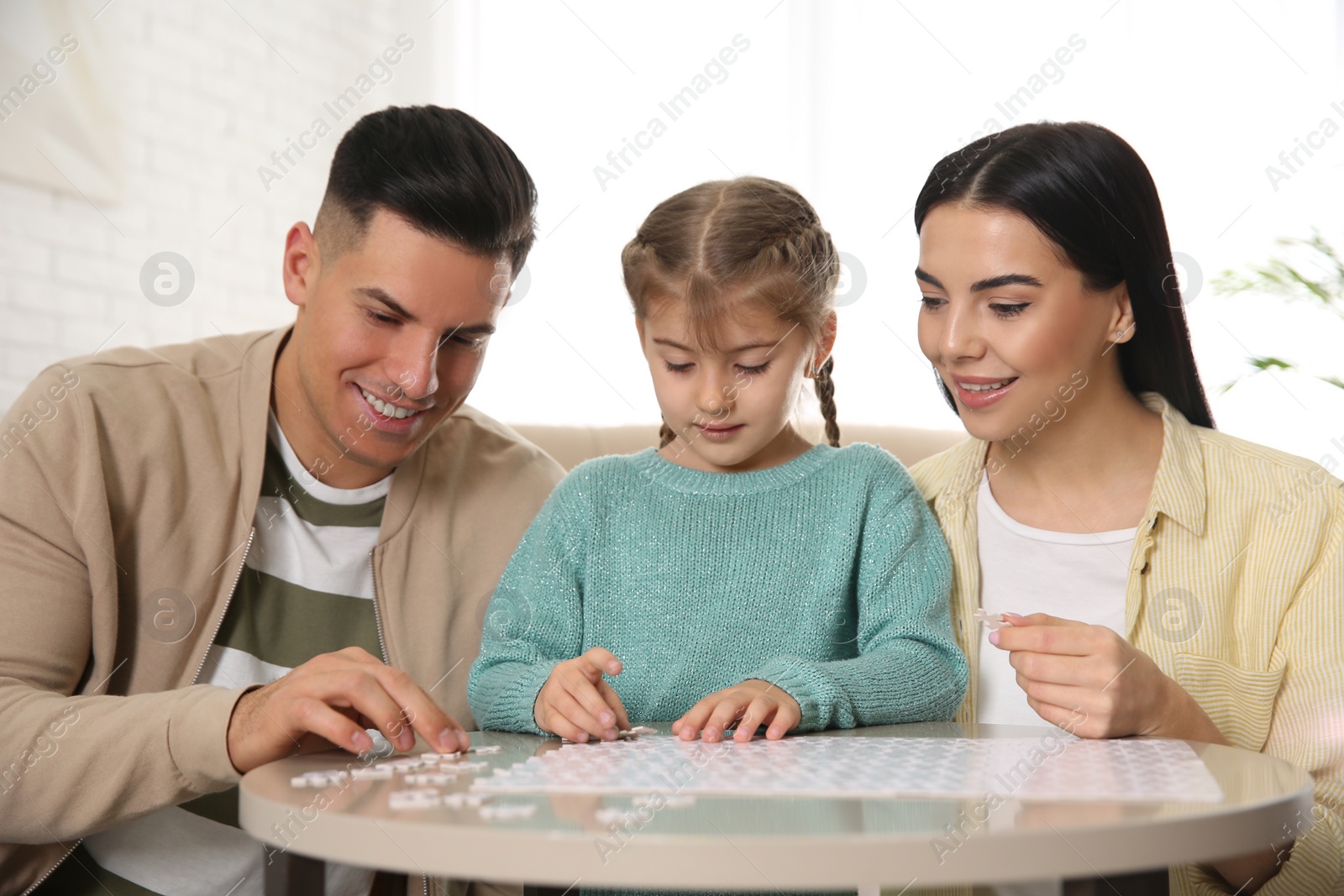 Photo of Happy family playing with puzzles at home