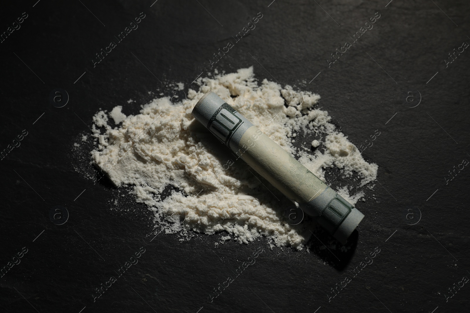 Photo of Drug addiction. Cocaine and rolled dollar banknote on dark textured table, closeup