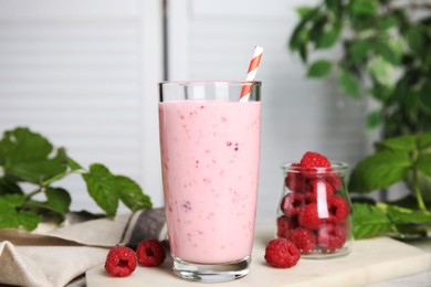 Photo of Glass of tasty raspberry smoothie on light table