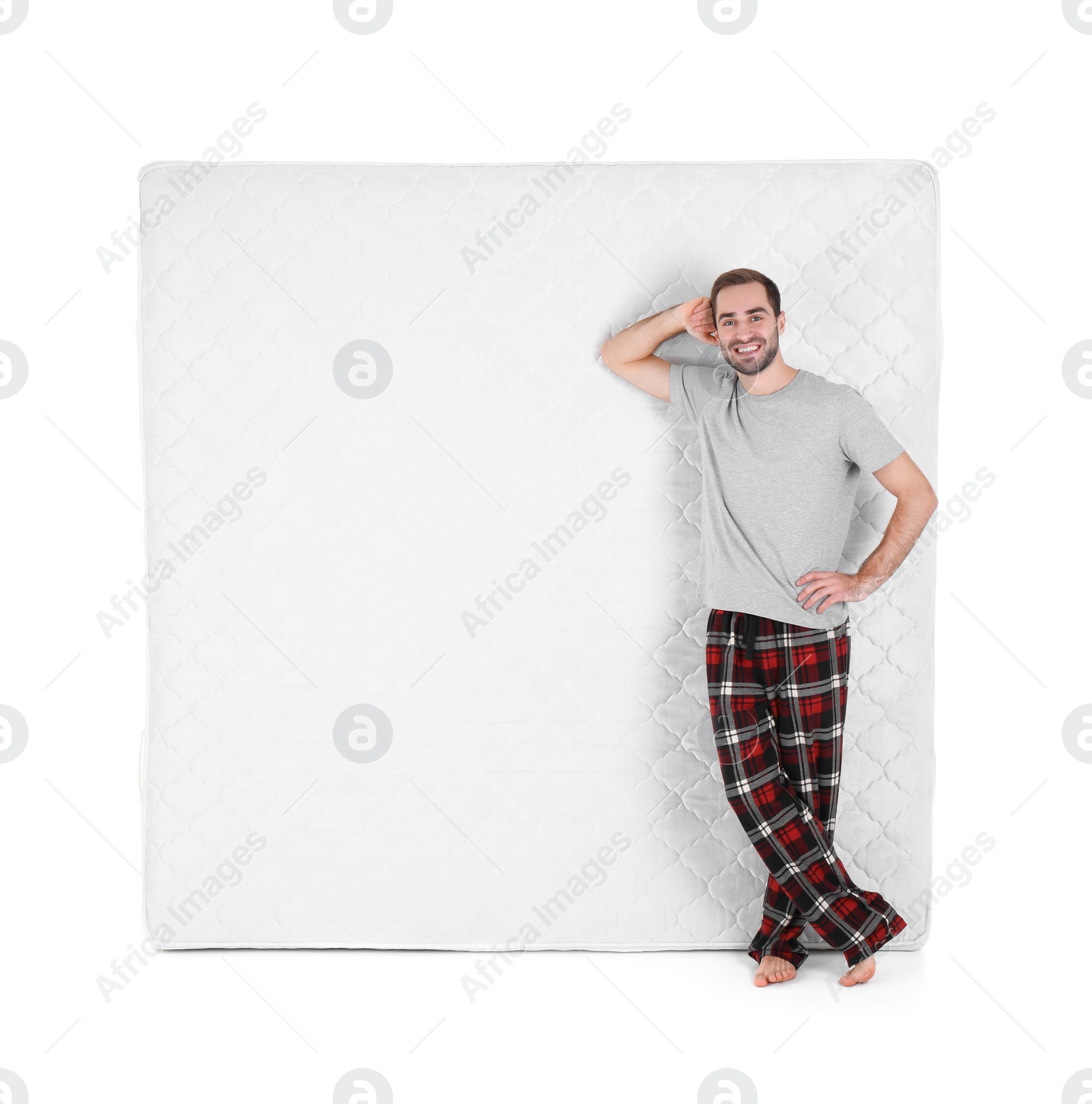 Photo of Young man with comfortable mattress isolated on white