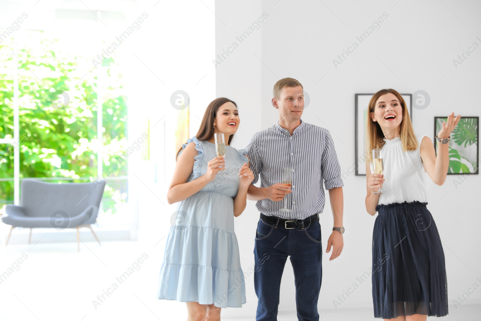 Photo of Group of people with glasses of champagne at exhibition in art gallery