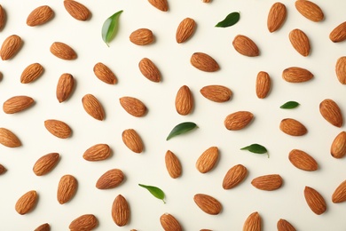 Composition with organic almond nuts on light background, top view