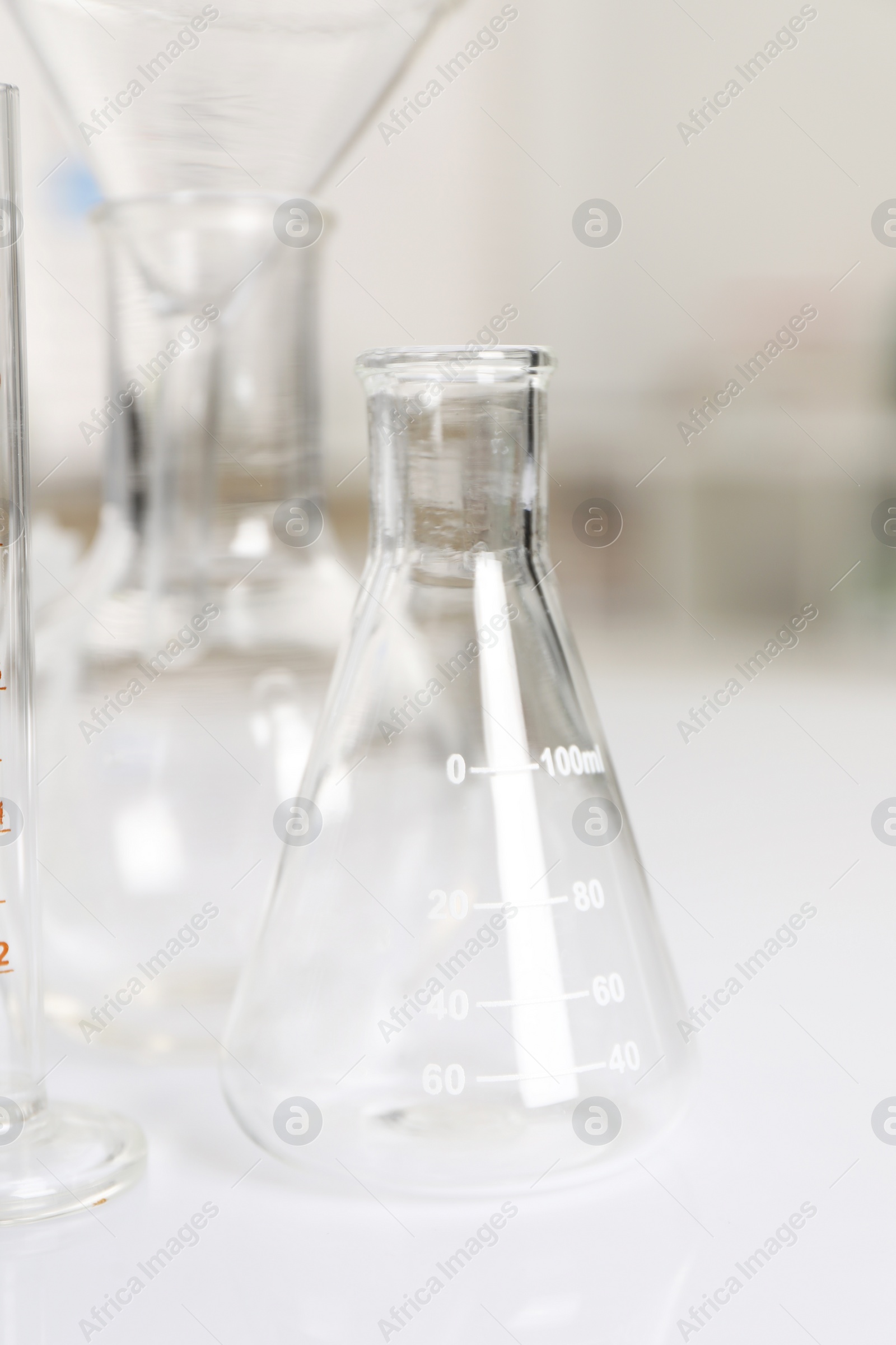 Photo of Laboratory analysis. Glass flasks on white table indoors, closeup