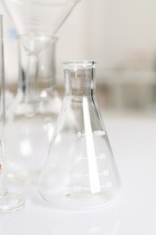 Photo of Laboratory analysis. Glass flasks on white table indoors, closeup