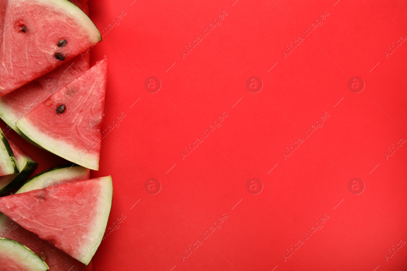 Photo of Slices of ripe watermelon on red background, flat lay. Space for text