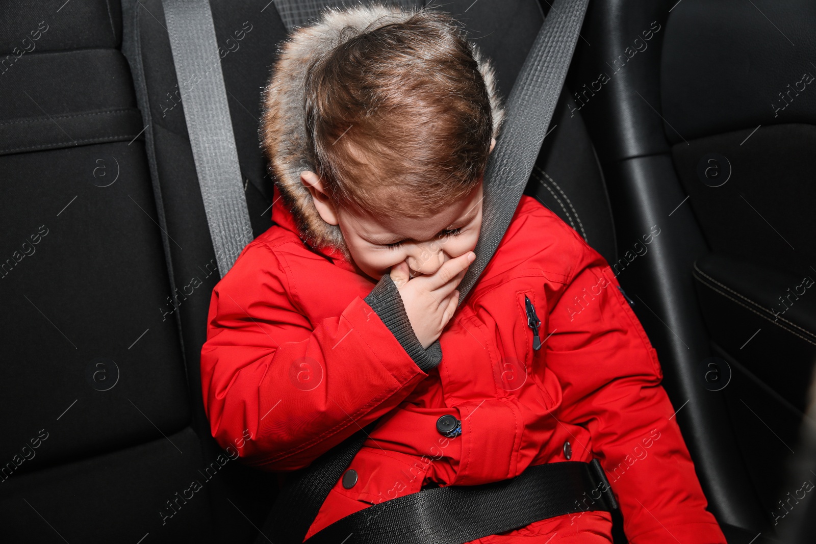 Photo of Little boy suffering from nausea in car