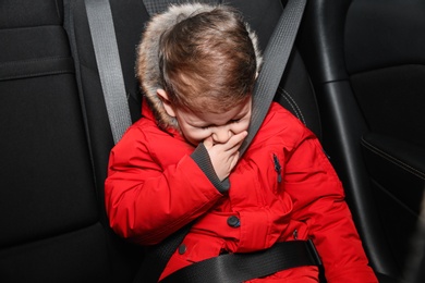 Little boy suffering from nausea in car