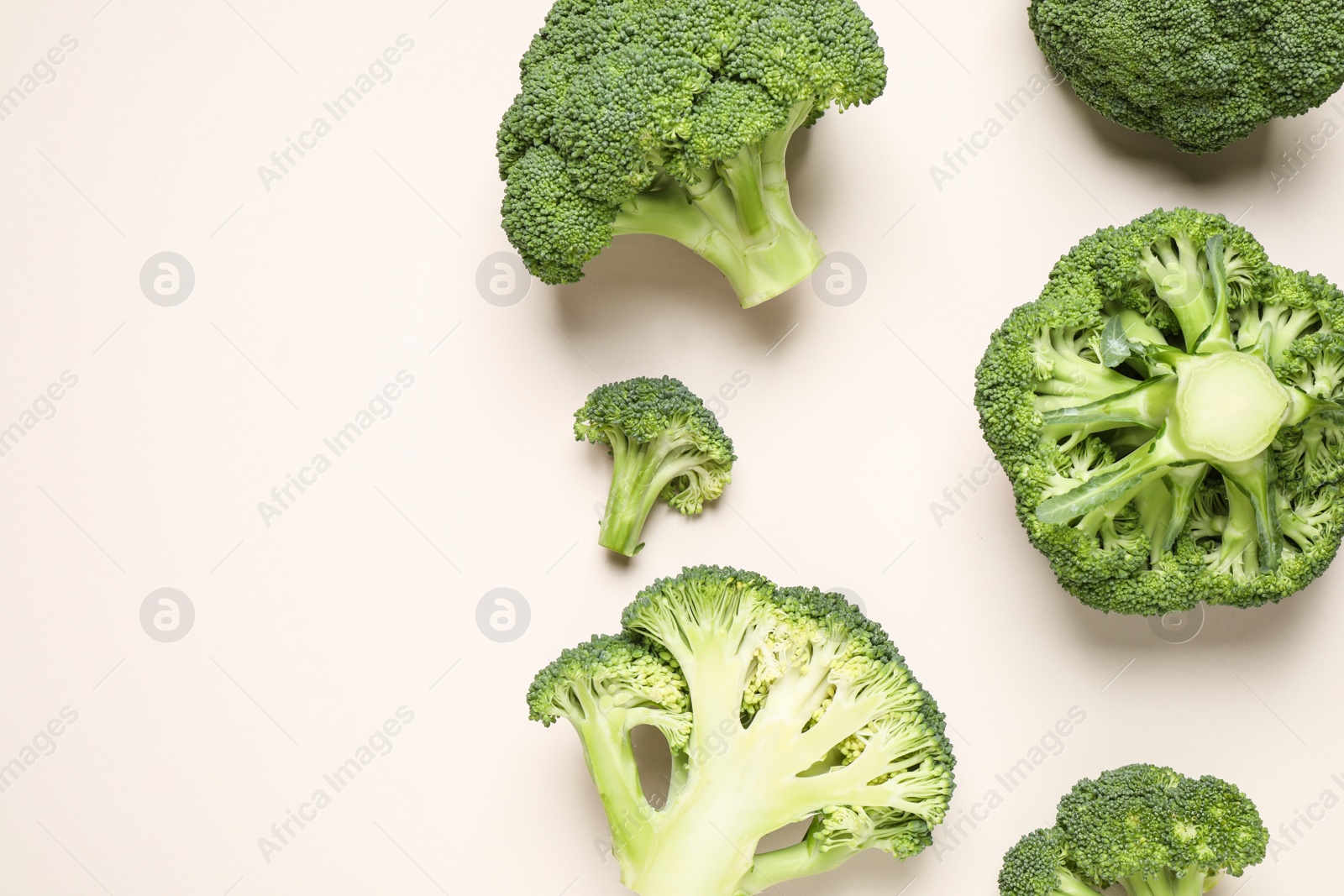 Photo of Fresh tasty broccoli on light beige background, flat lay