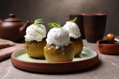 Delicious baked apples with ice cream and mint served on grey table