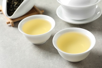 Photo of Cups of Tie Guan Yin oolong tea on grey table