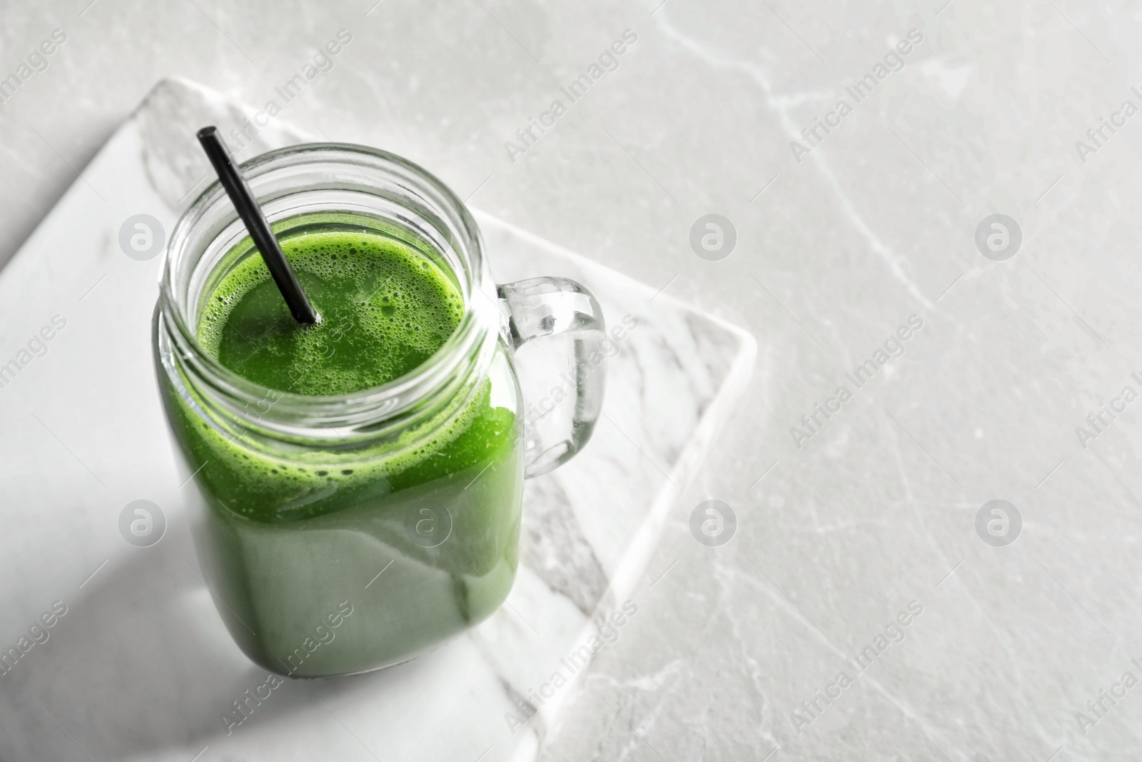 Photo of Mason jar with delicious detox juice on table