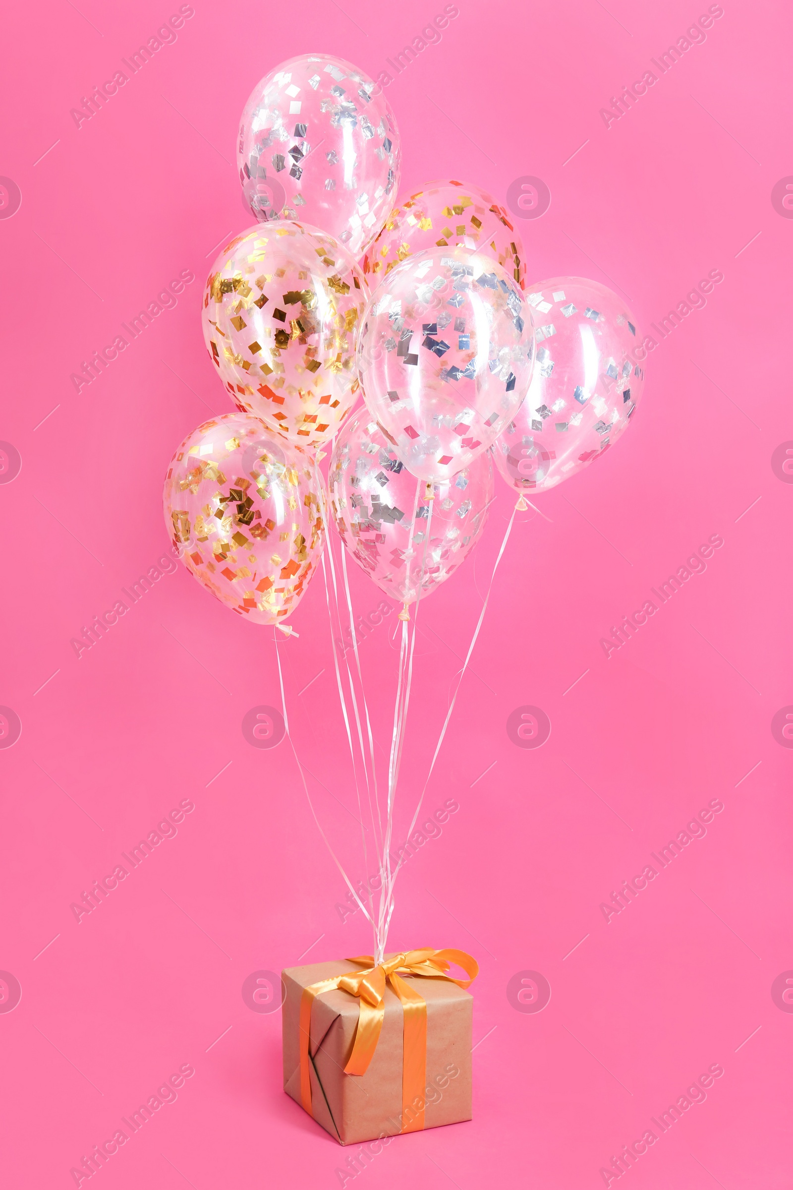 Photo of Bright balloons and gift box on color background