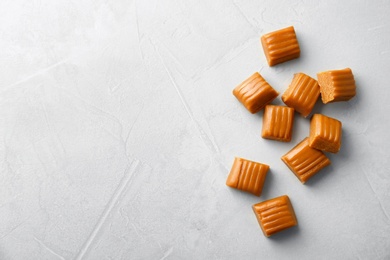 Photo of Delicious caramel candies on light background