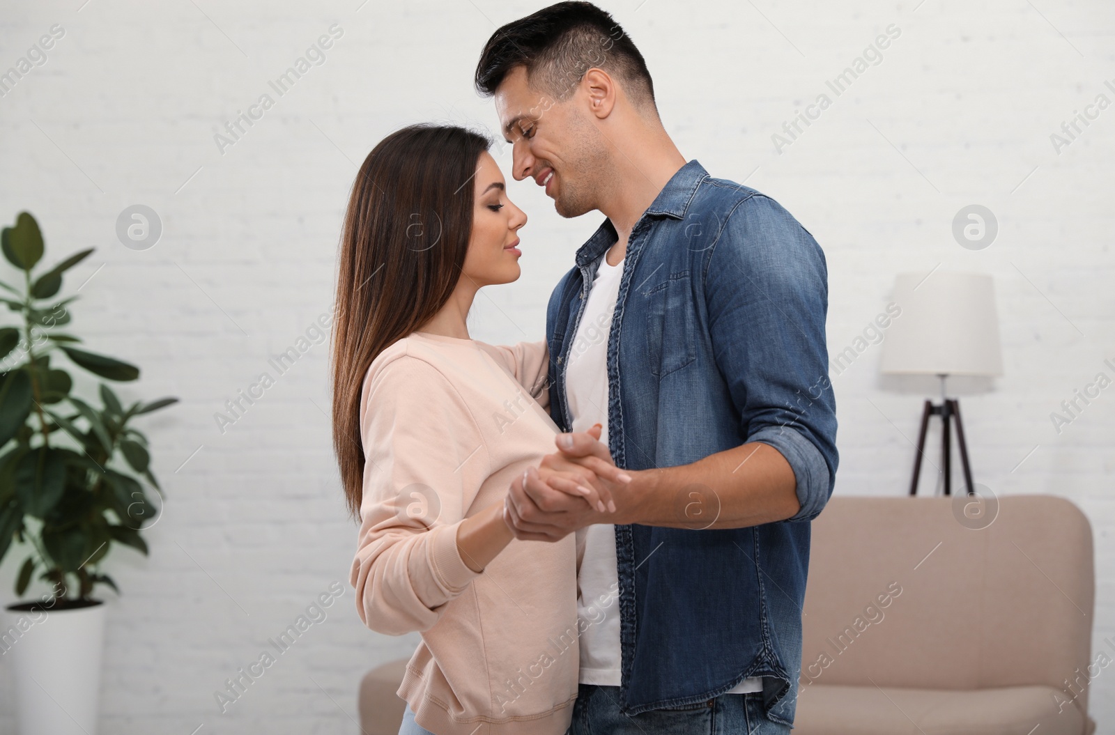 Photo of Happy couple dancing in living room at home