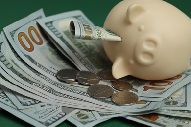 Photo of Money exchange. Dollar banknotes, piggy bank and coins on table, closeup