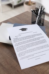 Photo of Acceptance letter from university, stationery and books on wooden table indoors