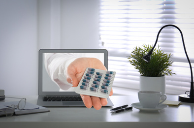 Image of Ordering medications online. Pharmacist giving pills from laptop screen