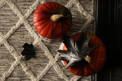 Photo of Orange pumpkins on rug, top view. Halloween decorations