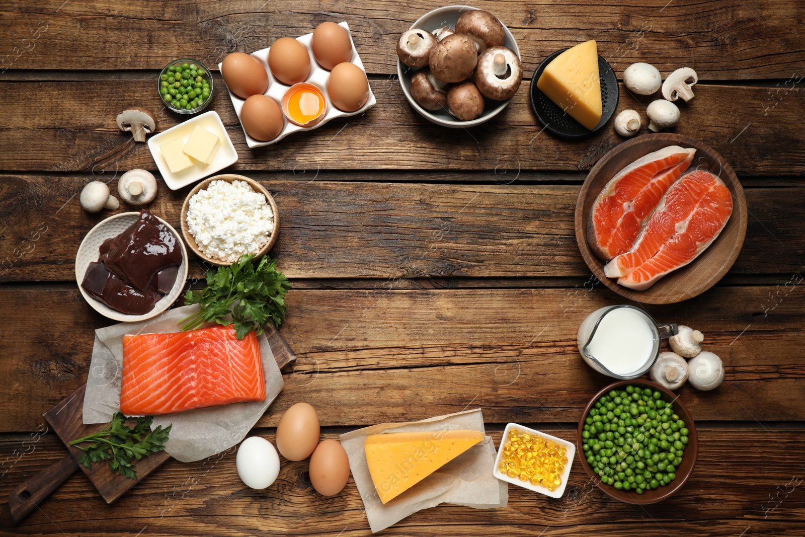 Photo of Flat lay composition with products rich in vitamin D on wooden table. Space for text