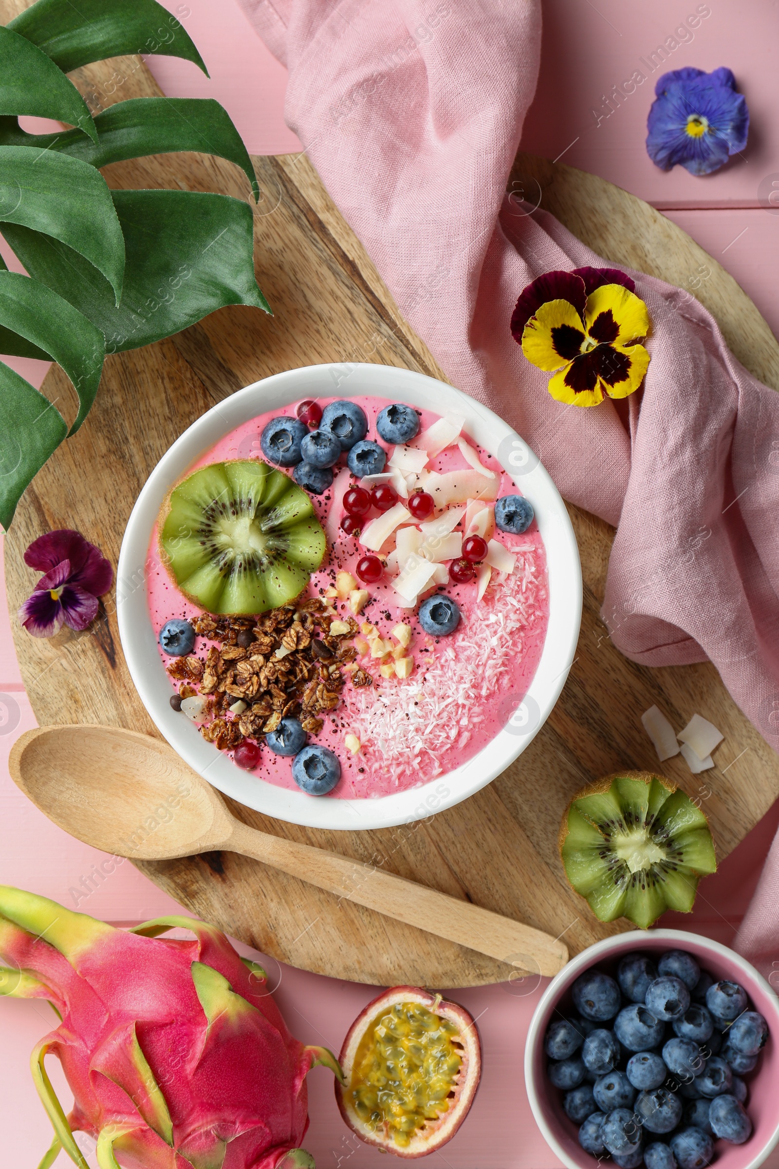 Photo of Flat lay composition with tasty smoothie bowl on pink wooden table