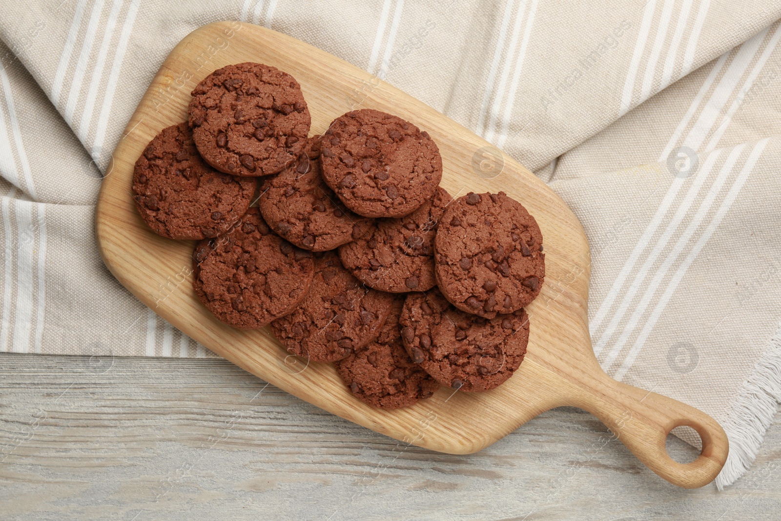 Photo of Delicious chocolate chip cookies on light wooden table, top view