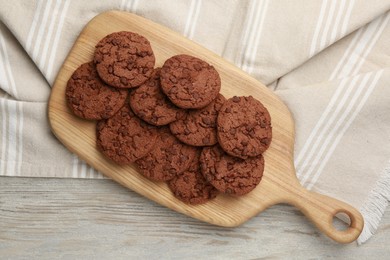 Delicious chocolate chip cookies on light wooden table, top view