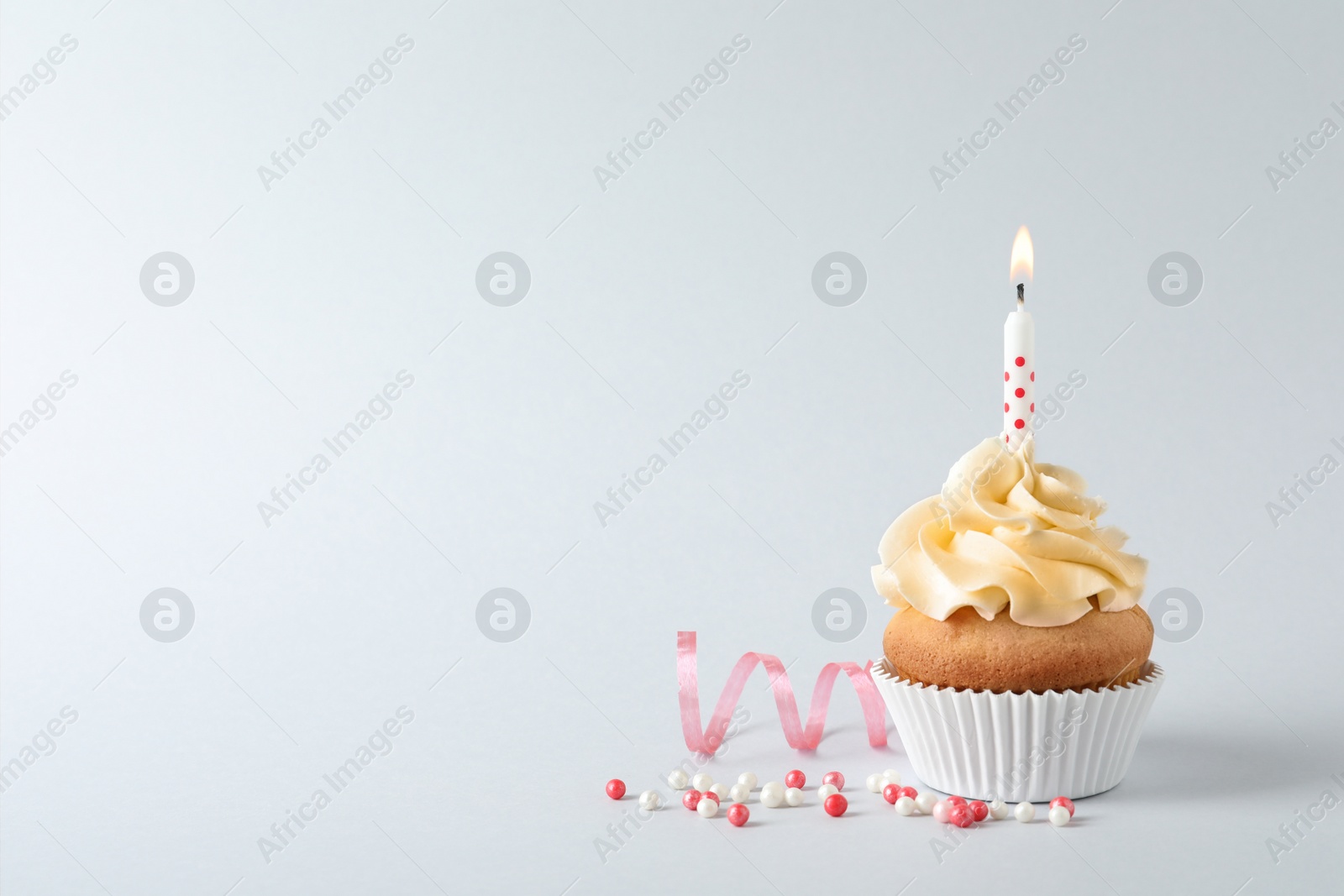 Photo of Delicious birthday cupcake with candle and space for text on gray background