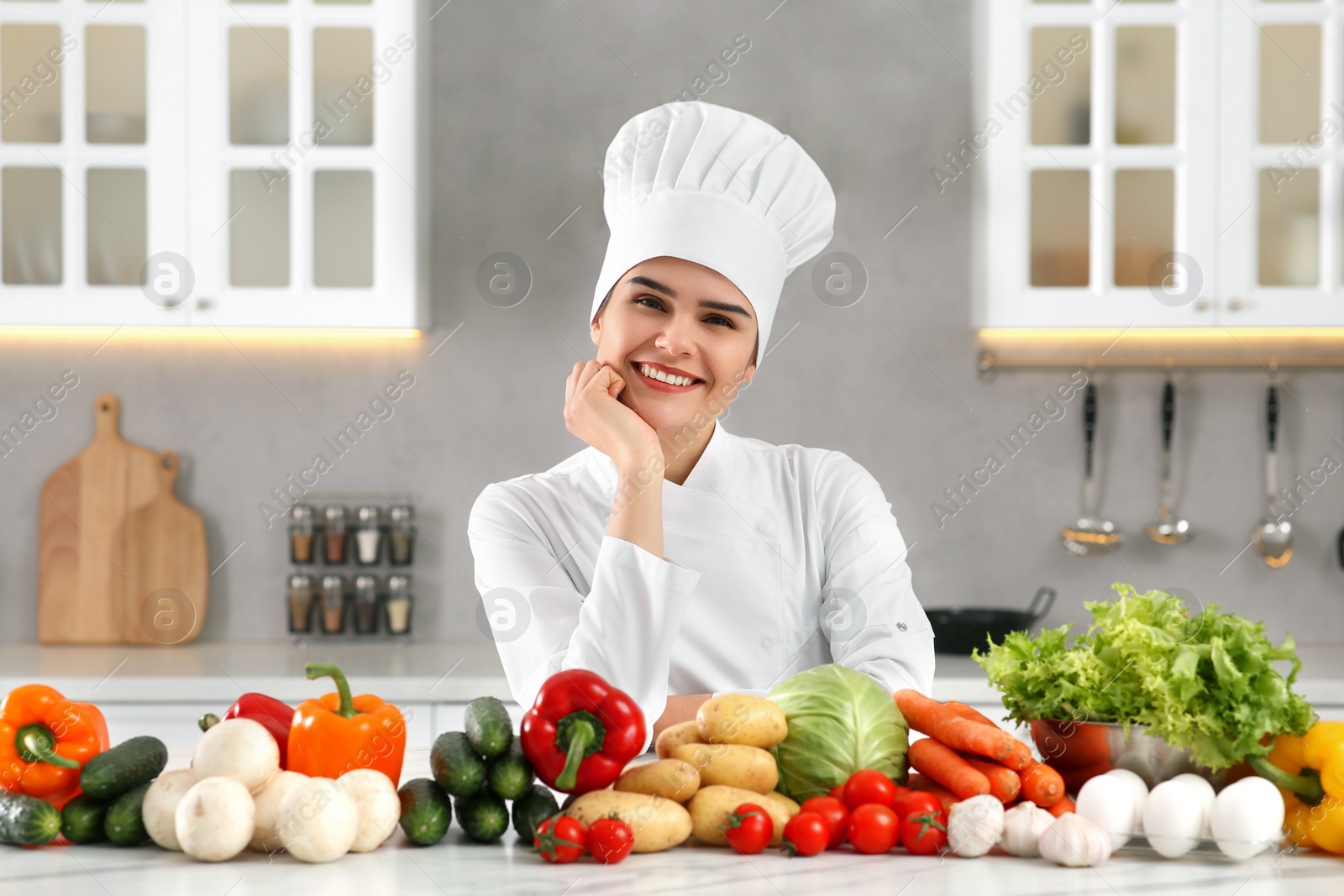 Photo of Portrait of happy chef near fresh vegetables in kitchen