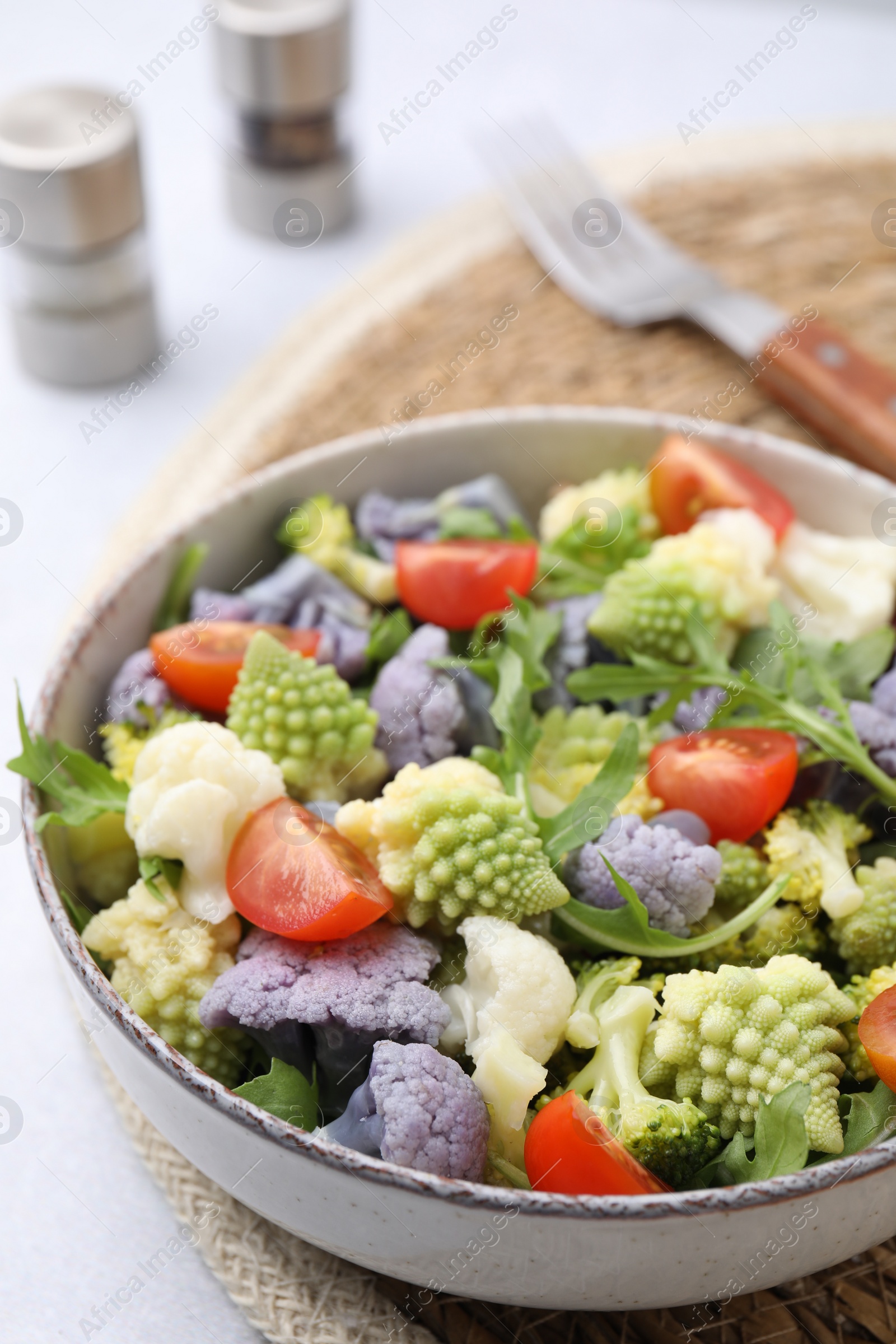 Photo of Delicious salad with cauliflower and tomato served on white table, closeup