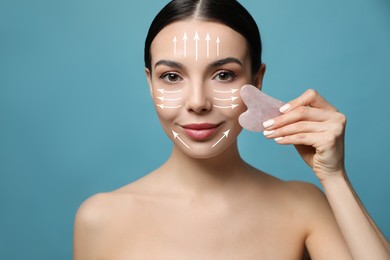 Beautiful young woman doing facial massage with gua sha tool on blue background, closeup