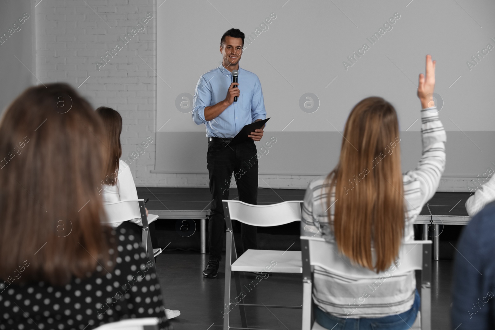 Photo of Male business trainer giving lecture in conference room with projection screen