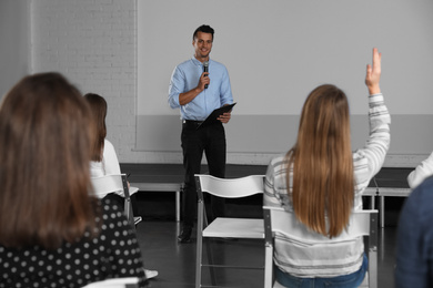 Photo of Male business trainer giving lecture in conference room with projection screen