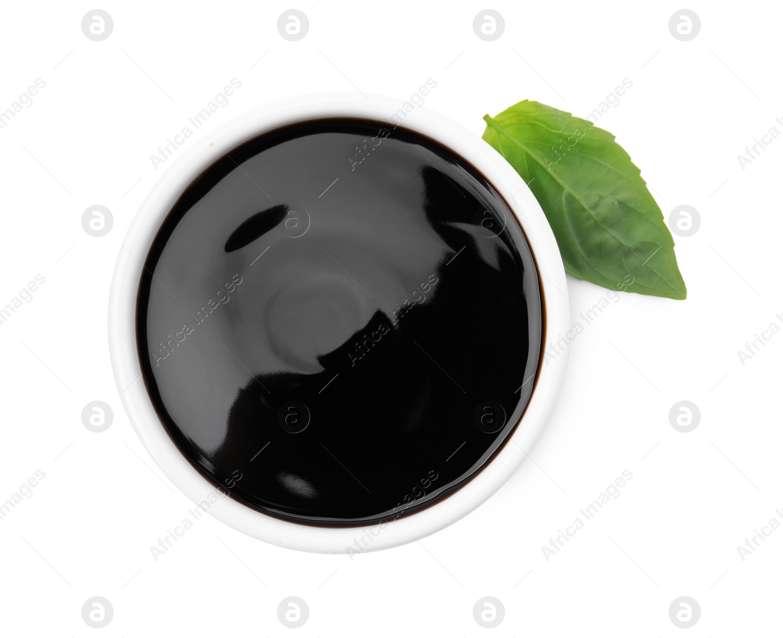 Photo of Balsamic glaze and basil leaf on white background, top view