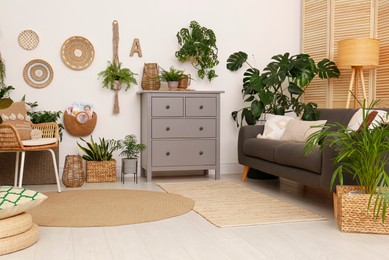 Living room interior with stylish furniture and green plants