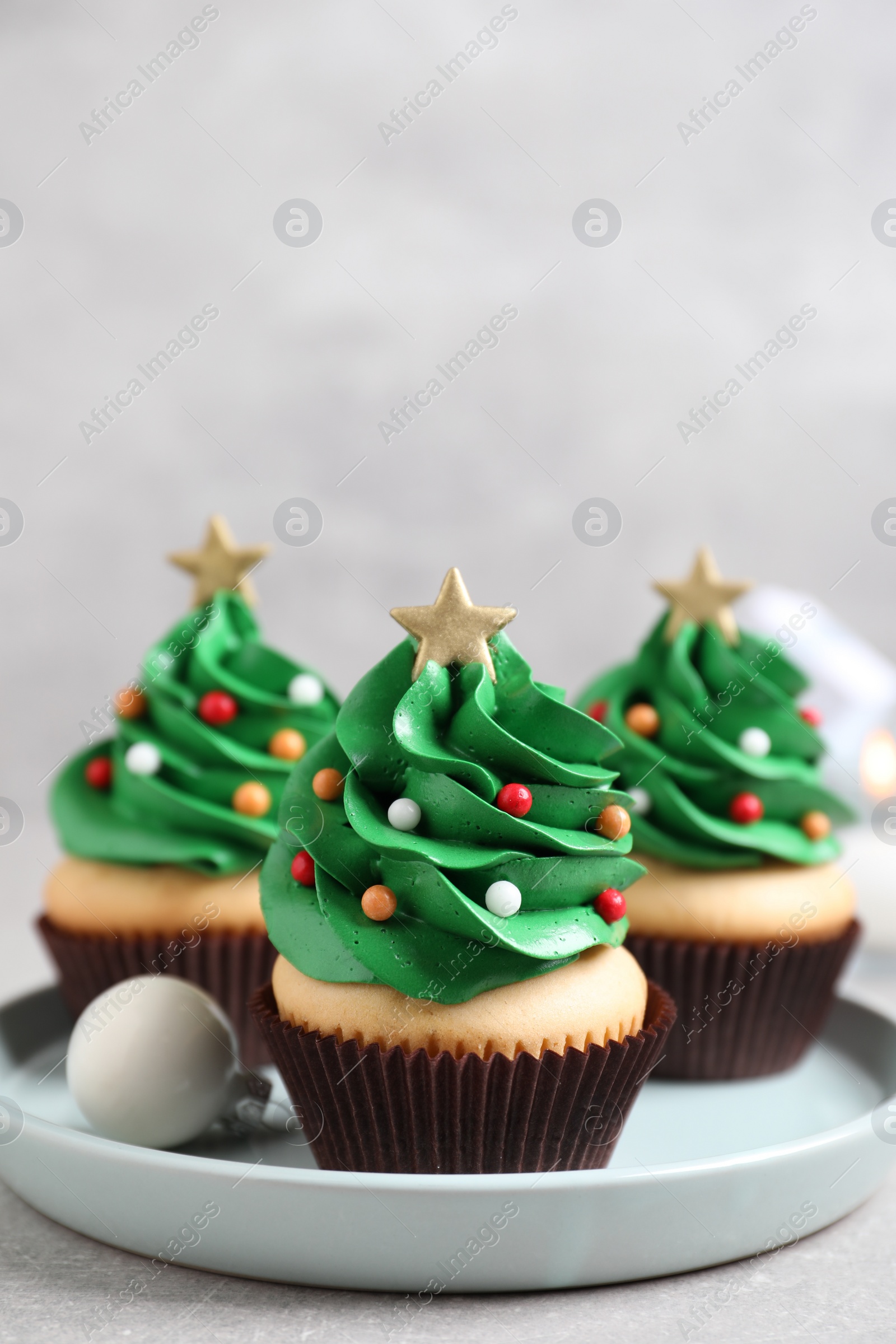 Photo of Christmas tree shaped cupcakes on light grey table