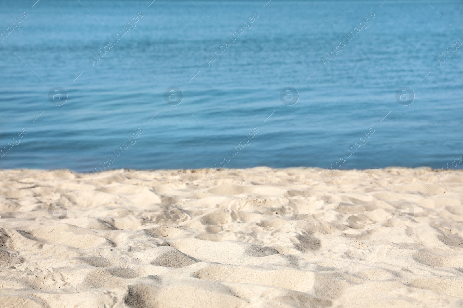 Photo of View of sea water and beach sand on sunny summer day