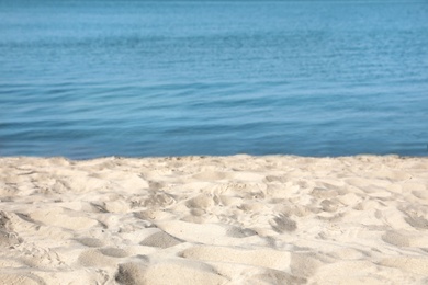 View of sea water and beach sand on sunny summer day