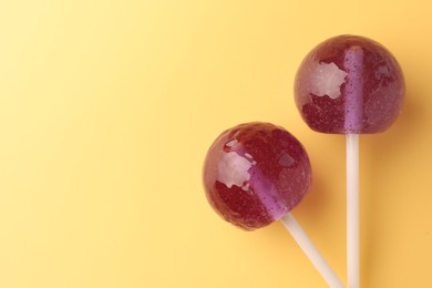 Tasty lollipops on yellow background, flat lay. Space for text