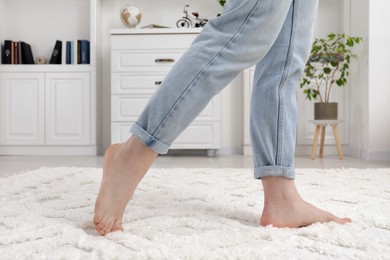 Photo of Woman standing on beige carpet in room, closeup