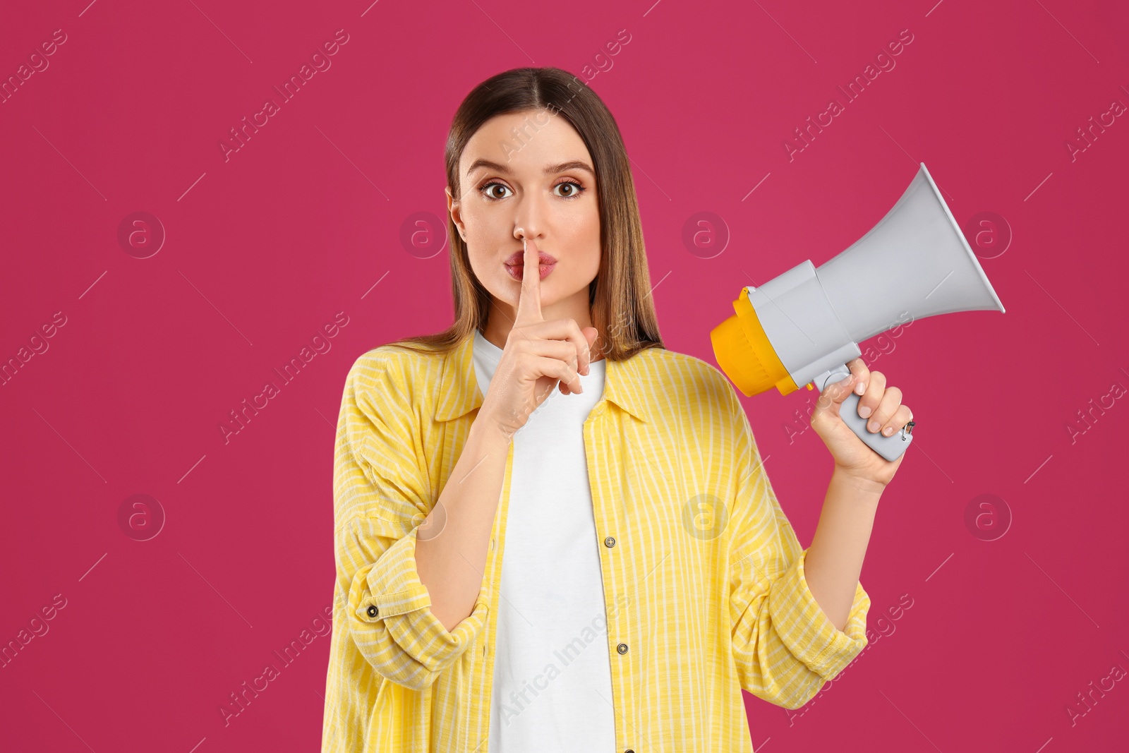 Photo of Young woman with megaphone on pink background