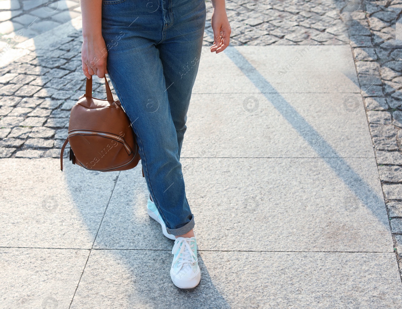Photo of Woman in stylish sneakers walking outdoors, closeup