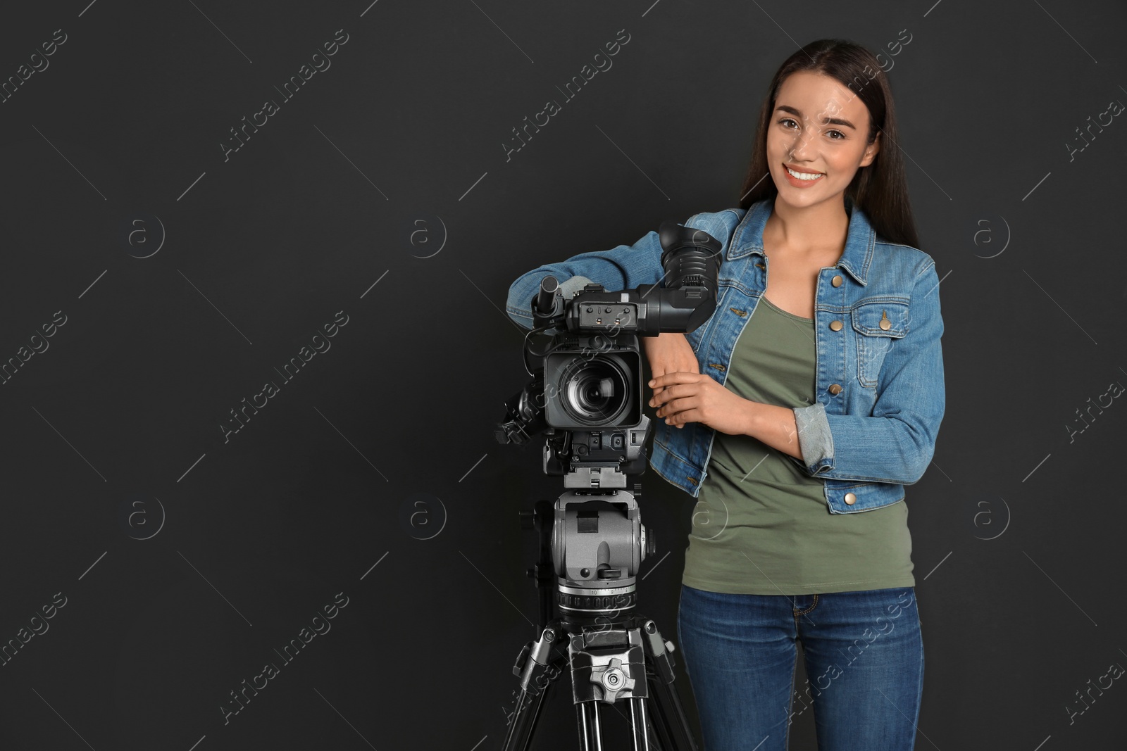 Photo of Operator with professional video camera on black background, space for text