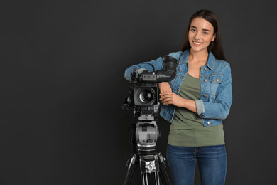 Photo of Operator with professional video camera on black background, space for text