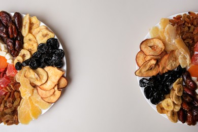 Photo of Plates with different dried fruits on white background, top view