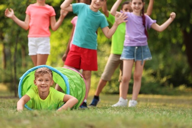 Cute little child playing with friends in park, space for text