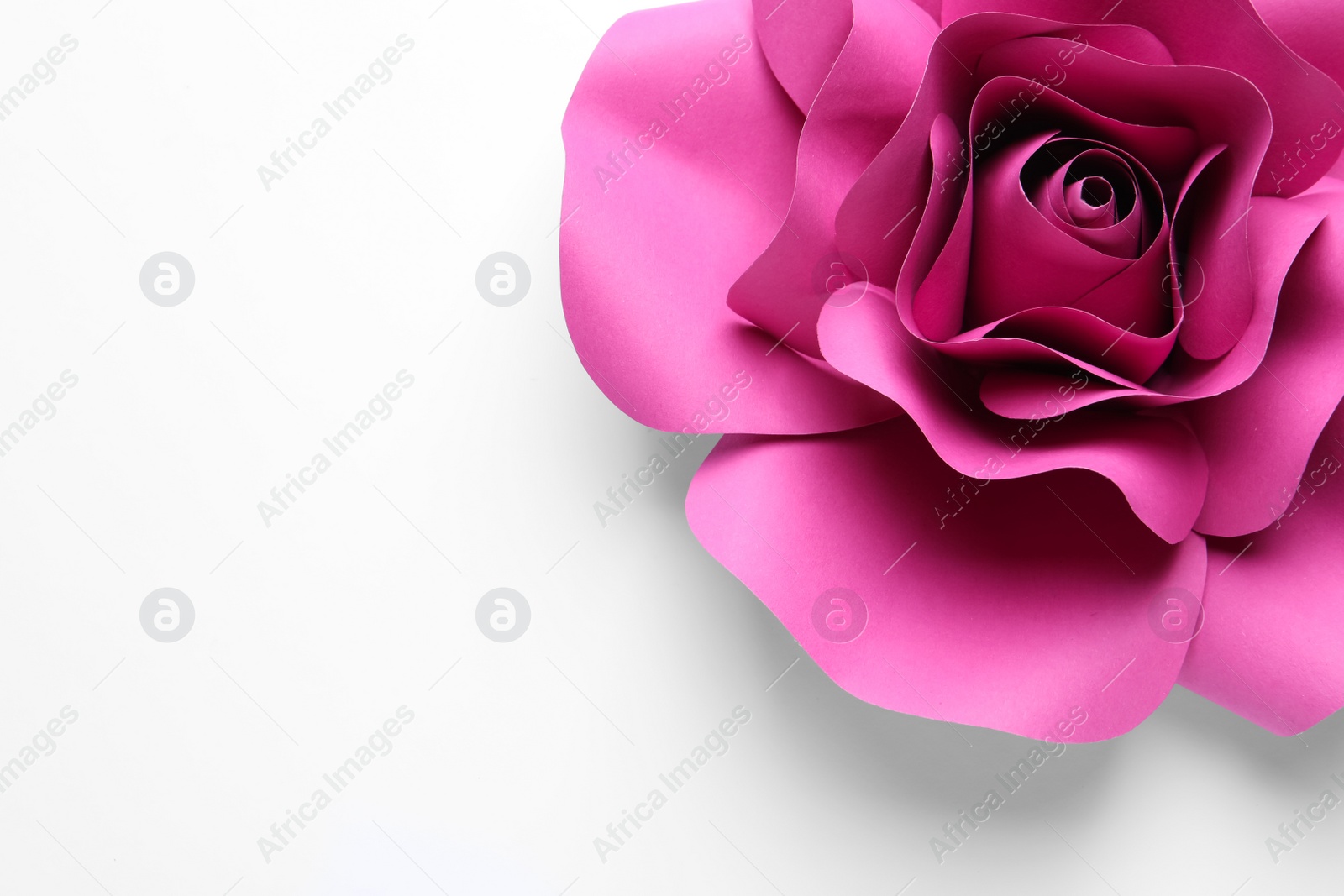 Photo of Beautiful pink flower made of paper on white background, top view