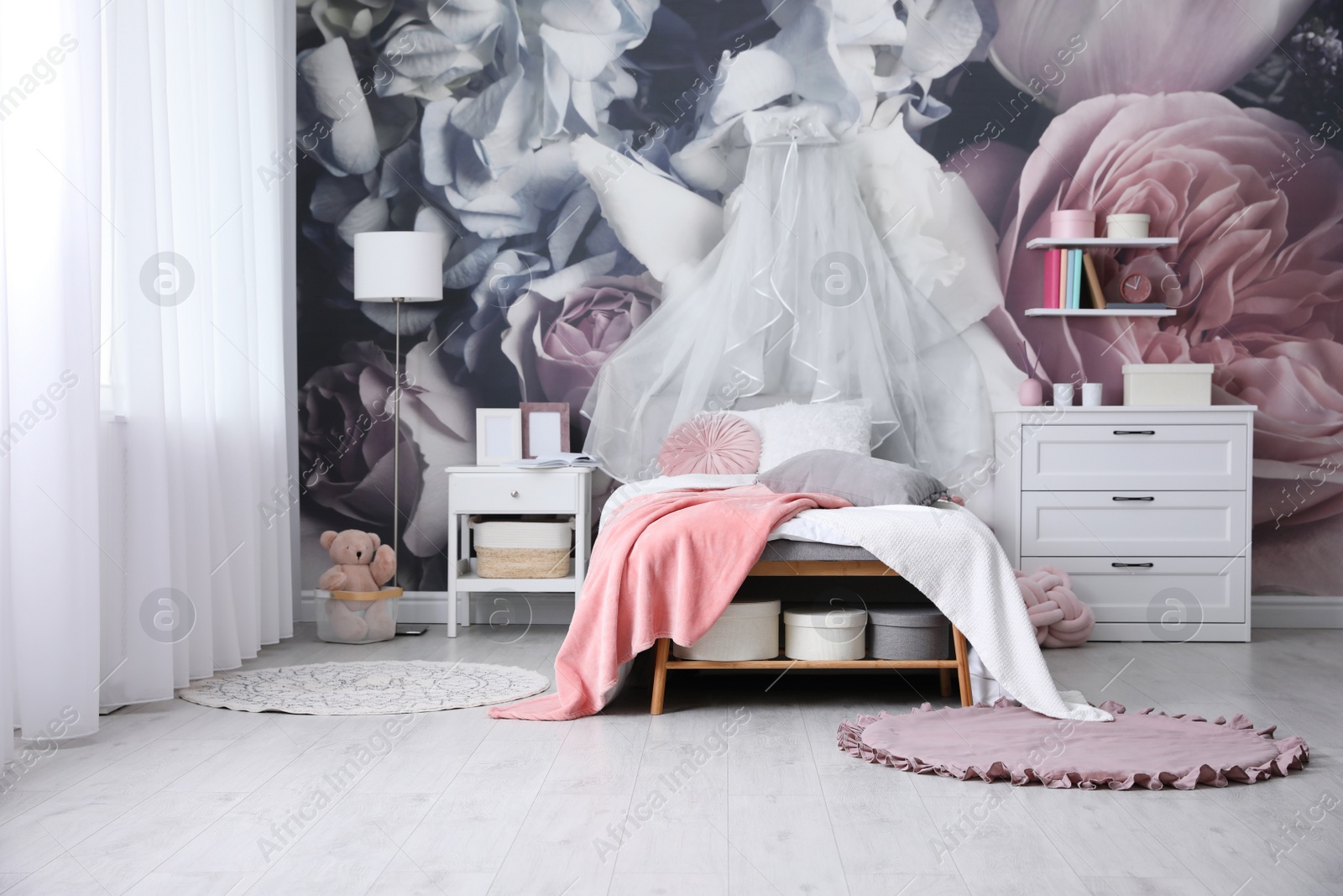 Photo of Teenage girl's room interior with comfortable bed and floral wallpaper. Idea for stylish design