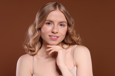 Portrait of beautiful woman with blonde hair on brown background